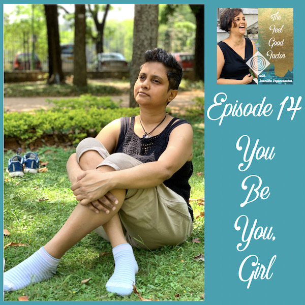 Susmitha Veganosaurus sitting on grass. Knees bent, legs crossed, hands crossed over knees. Looking up and away to the side thoughtfully. Super short hair. The Feel Good Factor Podcast. Episode 14. You be you, girl. Be yourself and be happy.