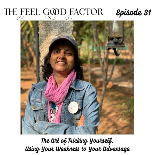 The Feel Good Factor. Episode 31. Susmitha smiling at the camera. Arms folded in front of her. Leaning against a pillar. The Art of Tricking Yourself, Using Your Weakness to Your Advantage.