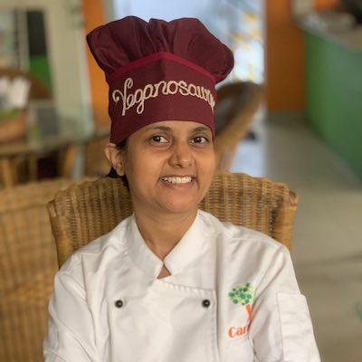 Chef Susmitha Subbaraju Veganosaurus smiling. Wearing chef coat and hat.