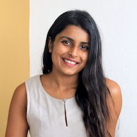 Young Indian woman with long hair, Samyukta Kartik of Yume Culinary, smiling at the camera.