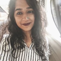 Shasvathi Siva of Cowvathi. Young Indian woman in a vertical striped top, smiling at the camera.