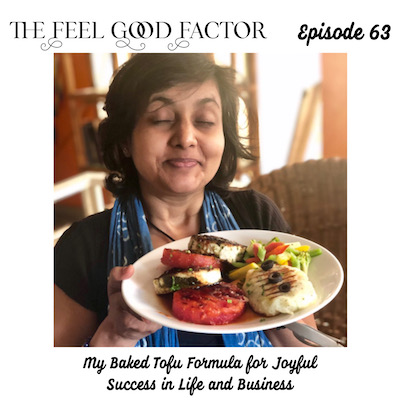The feel good factor podcast, episode 63. Susmitha (short, wavy haired Indian lady), closing eyes, holing out a plate of food to the camera and smiling. My baked tofu formula for joyful success in life and business.