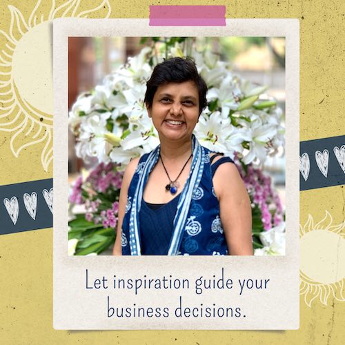 Heart and sun doodles on the background. In the center, a photo of Susmitha, short haired Indian lady, smilingly widely at the camera. Blurred flowers behind her. Text under photo: Let inspiration guide your business decisions.