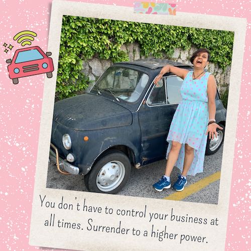 Polaroid style photo taped on to a textured pink background. Photo has Susmitha, Indian lady with short hair in a flowy, pink polka dotted dress and blue sport shoes. She’s leaning against a cute antique car and laughing expressively at the camera. Text under the photo: You don’t have to control your business at all times. Surrender to a higher power.