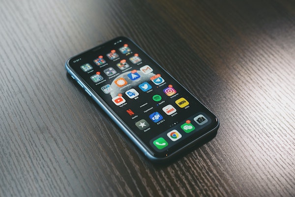 Smartphone on a tabletop. Lots of red notification badges on the apps shown on the screen. Are you addicted to your phone?