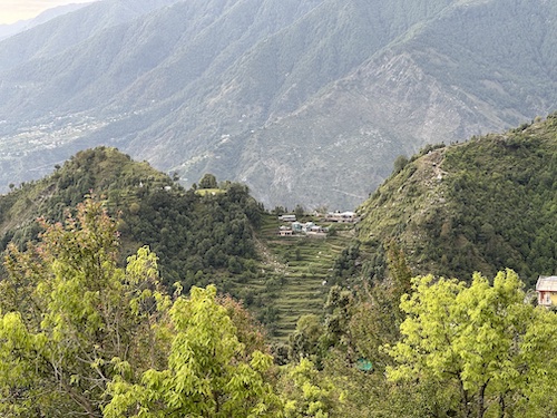 Fabulous view of valley. Mountains in the background. Tiny steps and houses nestled in the middle. Lush greenery all around.