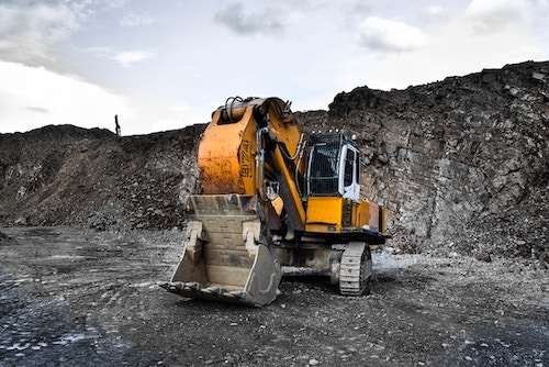 Yellow digger chugging along at its work.