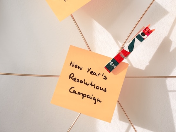 Post it note clipped into a wire. Written on it "new year's resolutions campaign."