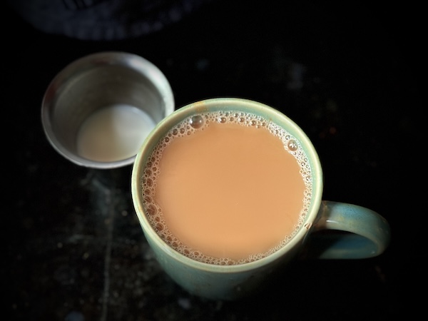 Vegan cashew mylk masala chai in a mug, cashew mylk next to it in a steel tumbler. Make plant milks and other dairy alternatives easily.