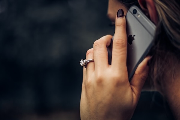 Person holding iphone to their ear. Vegan business coaching session.